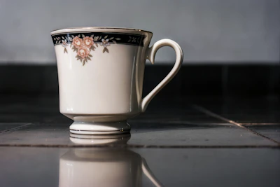 A cozy ceramic mug with a hand-painted floral design in warm mustard and coral tones.