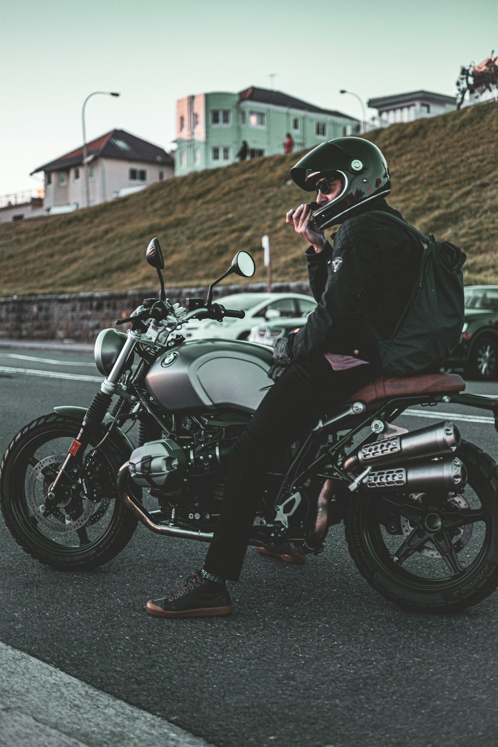 낮 동안 검은 색과 은색 오토바이를 타는 검은 색 재킷을 입은 남자