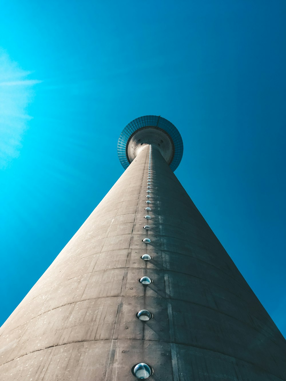 low angle photography of gray concrete tower under blue sky during daytime