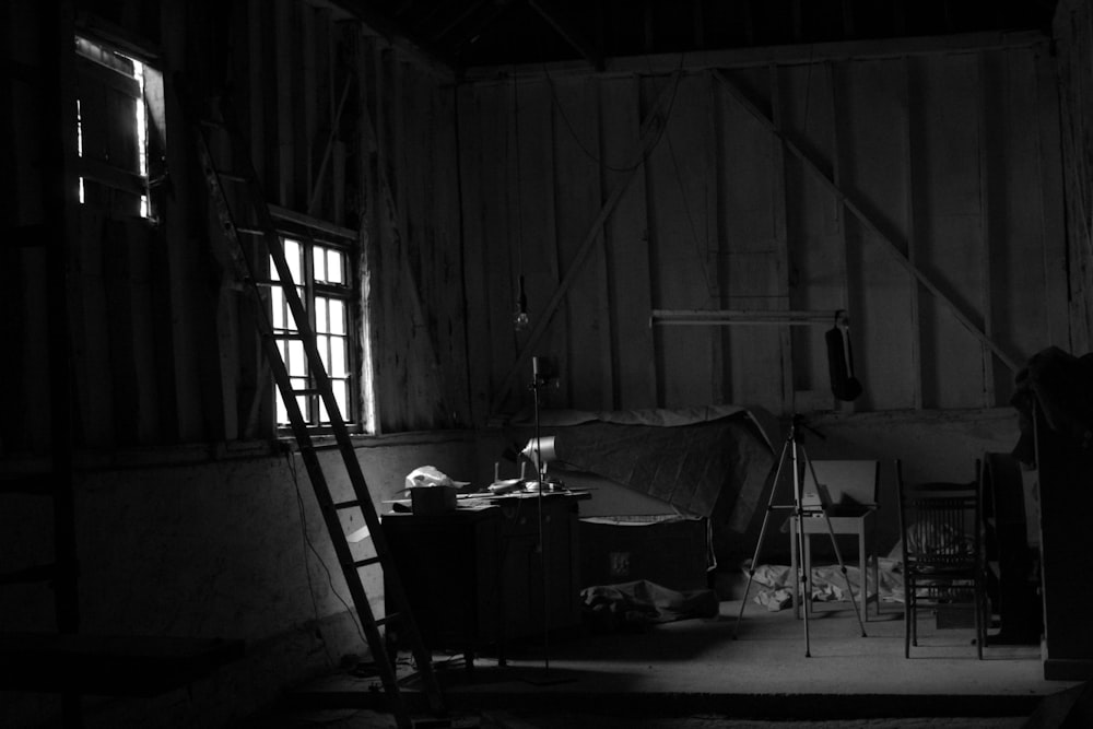 grayscale photo of a room with a table and chairs