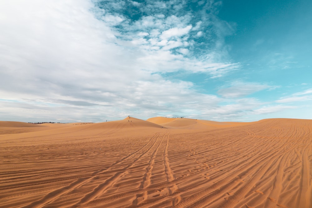 sable brun sous le ciel bleu pendant la journée