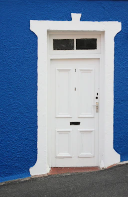 White PVC door panel leaning against a clean factory wall.