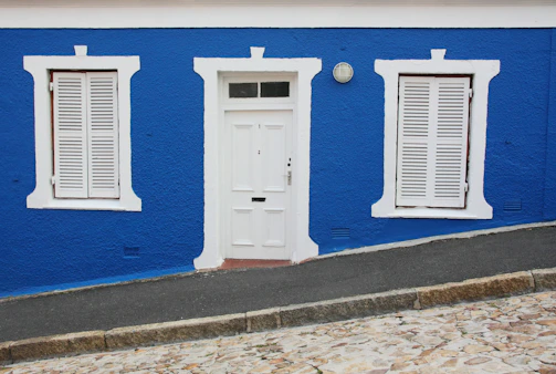Close-up of a clean, newly painted white facade with blue accents.