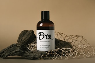 a bottle of broc cosmetics sits on a pile of branches