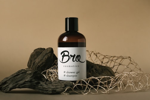 a bottle of broc cosmetics sits on a pile of branches