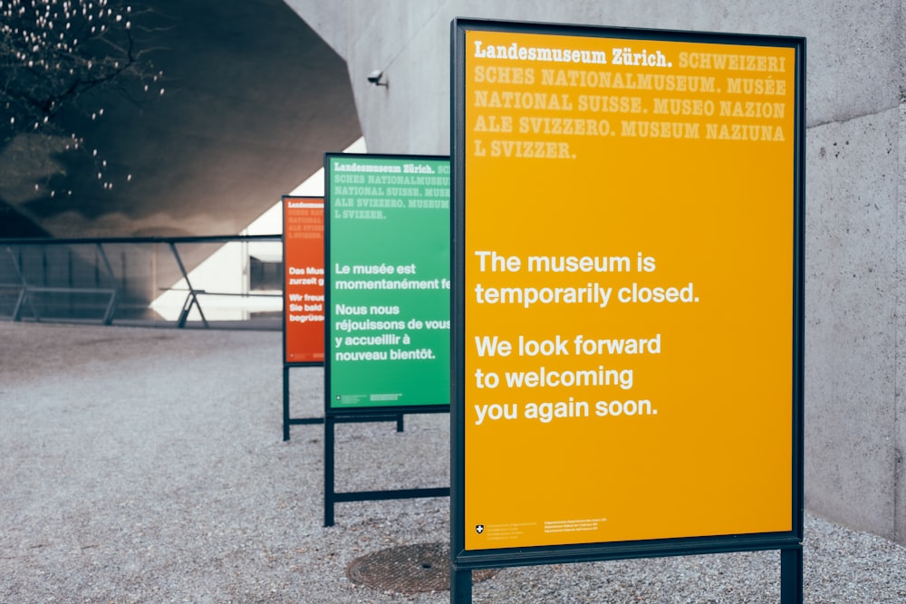 blue and yellow signage on gray concrete wall