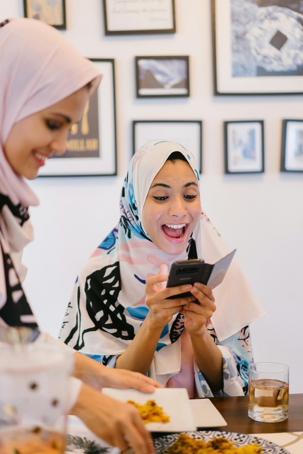 woman in white hijab holding black smartphone