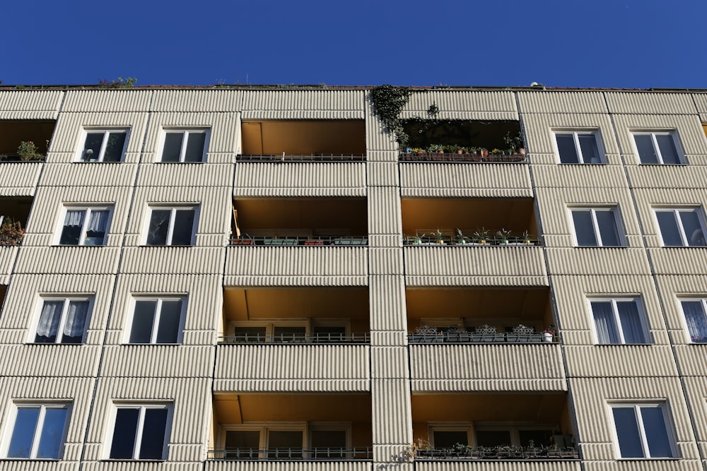 Weißes Betongebäude unter blauem Himmel tagsüber