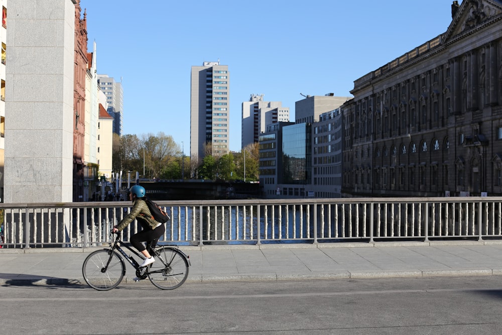 man in black jacket riding bicycle on road during daytime