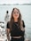 woman in black crew neck t-shirt wearing brown framed eyeglasses standing on rocky shore during