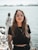 woman in black crew neck t-shirt wearing brown framed eyeglasses standing on rocky shore during