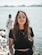 woman in black crew neck t-shirt wearing brown framed eyeglasses standing on rocky shore during
