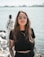 woman in black crew neck t-shirt wearing brown framed eyeglasses standing on rocky shore during
