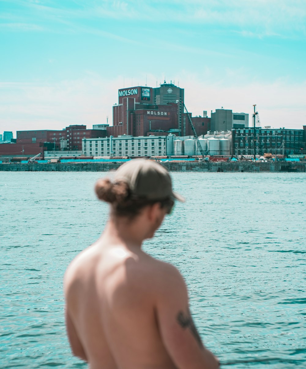 mulher de topless em pé perto do corpo de água durante o dia