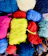 Close-up of colorful crochet yarn balls cascading in soft natural light.