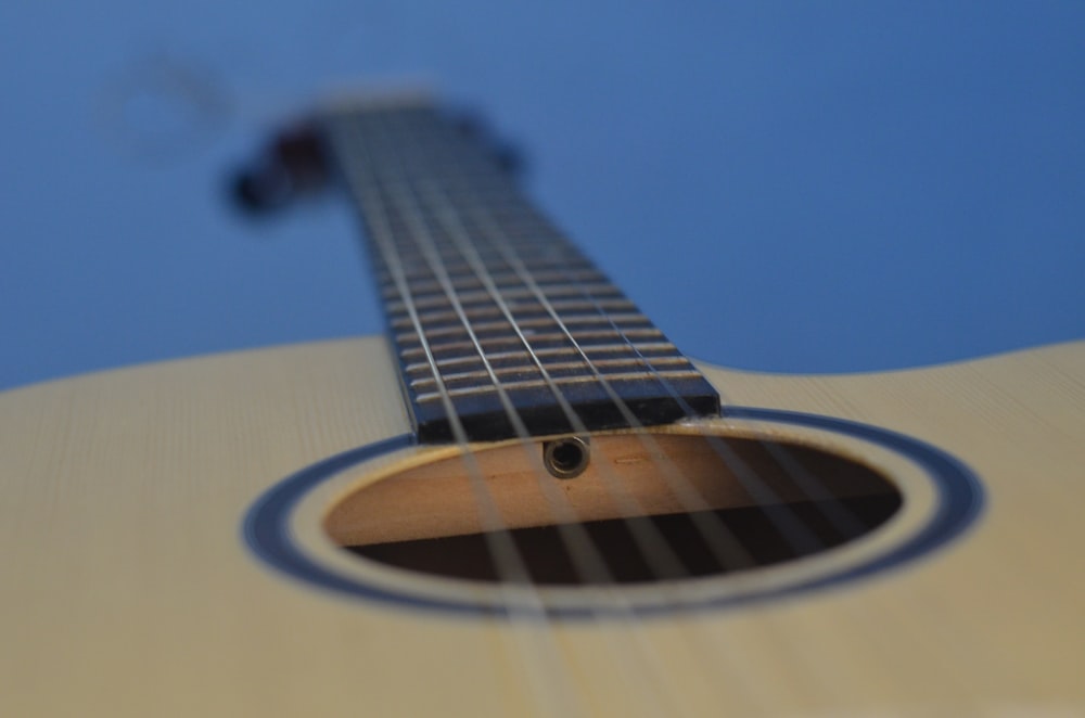 brown acoustic guitar in close up photography