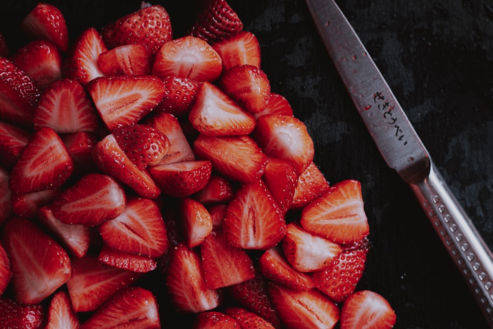 sliced strawberries on brown wooden chopping board