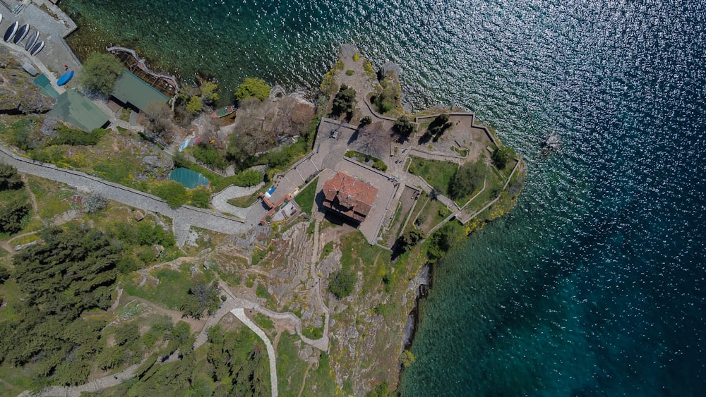 an aerial view of a house on the shore of a lake