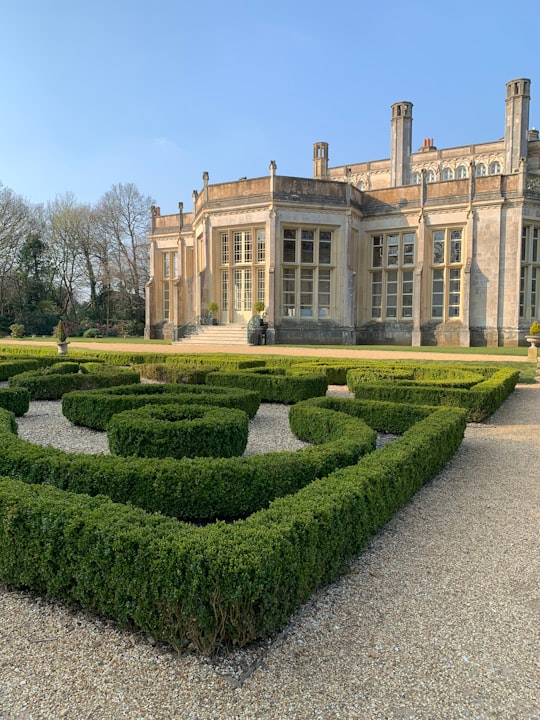 green grass field near brown concrete building during daytime in Highcliffe Castle United Kingdom