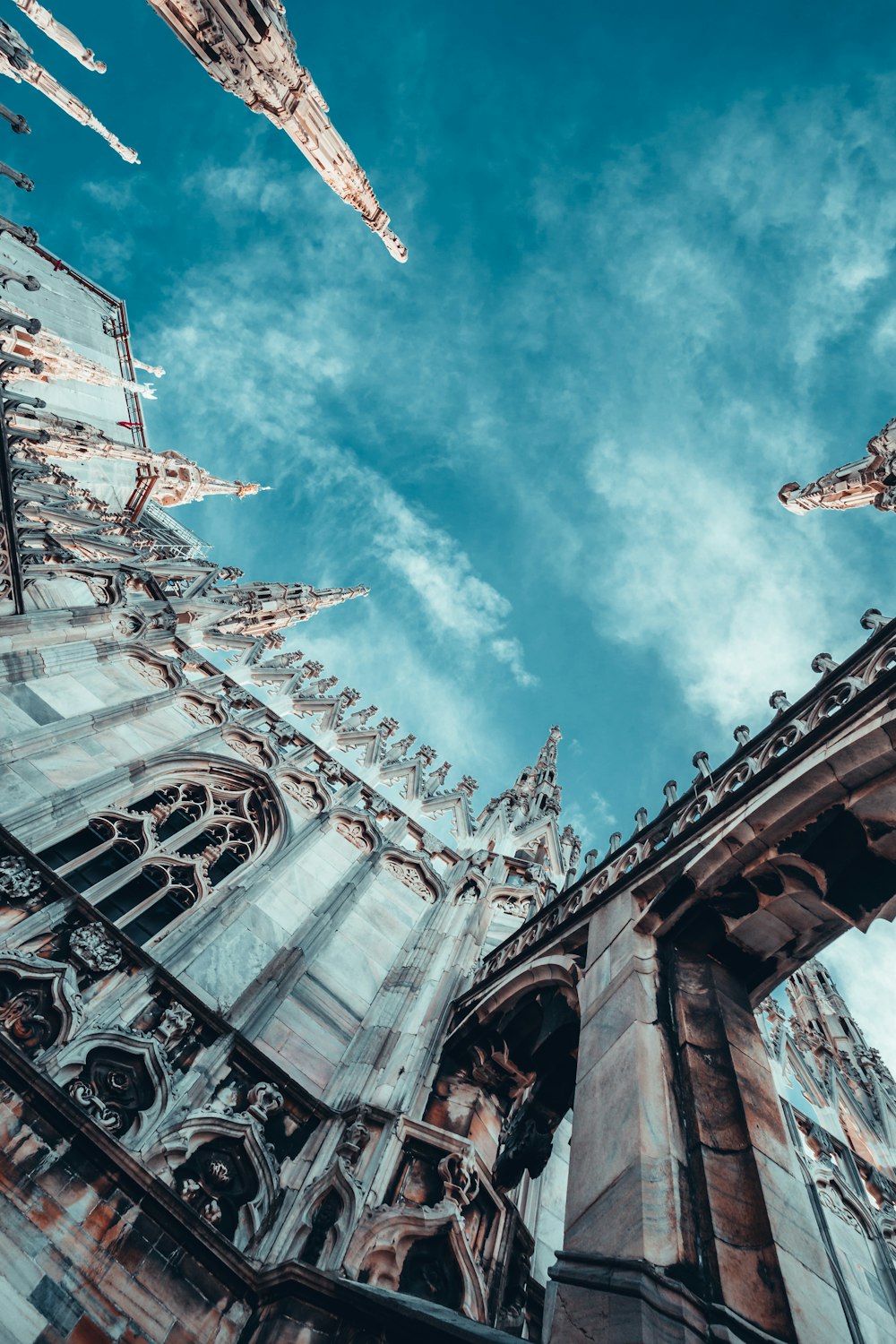 Fotografía de ángulo bajo de un edificio de hormigón blanco bajo el cielo azul durante el día