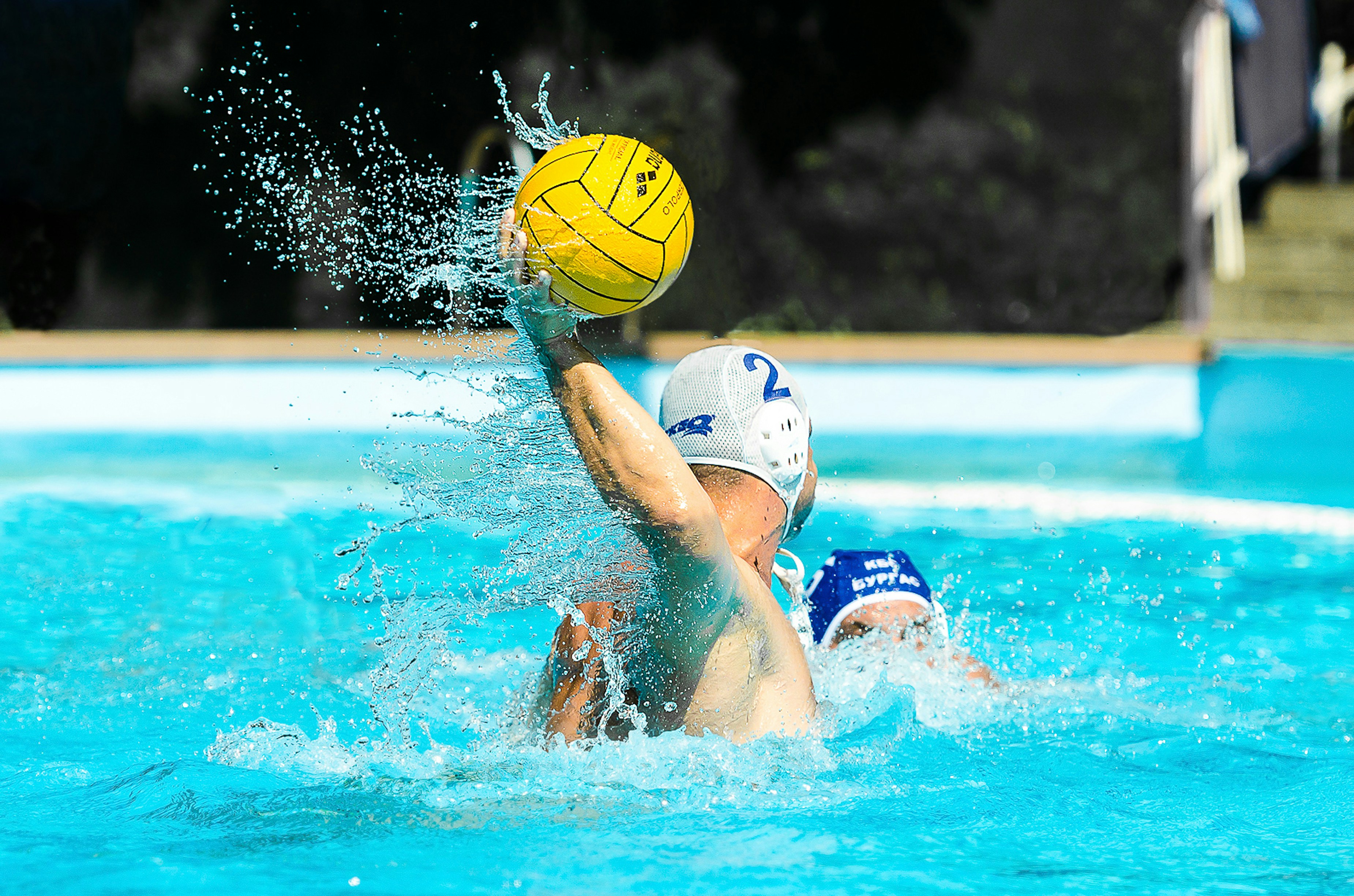orang di kolam renang memegang bola sepak kuning dan biru