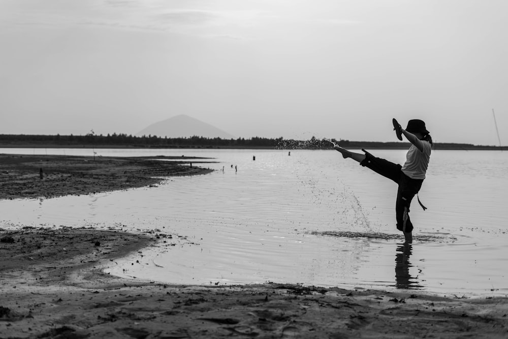 grayscale photo of man and woman walking on beach