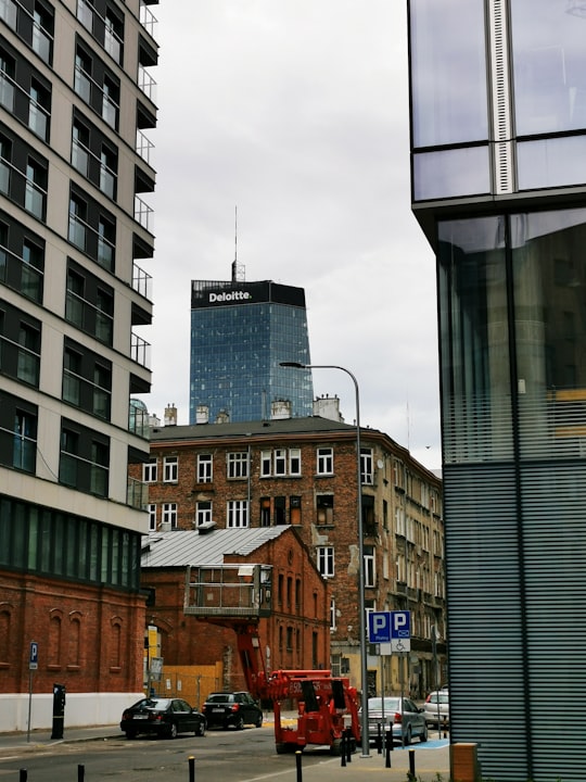 brown concrete building under white clouds during daytime in Warszawa Poland