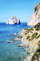 brown rock formation on blue sea under blue sky during daytime