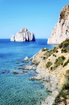 brown rock formation on blue sea under blue sky during daytime