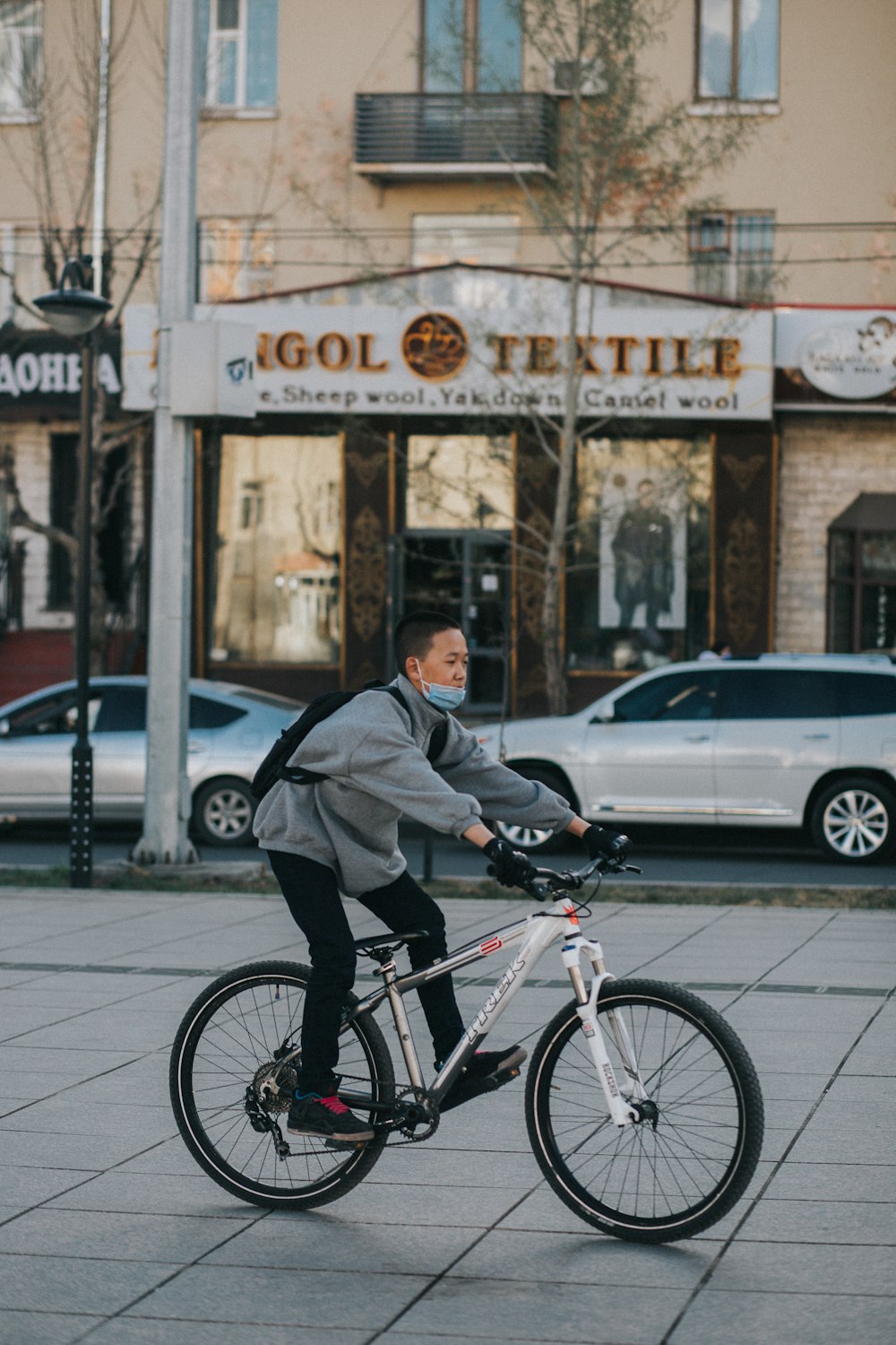 man in black jacket riding on black bicycle during daytime