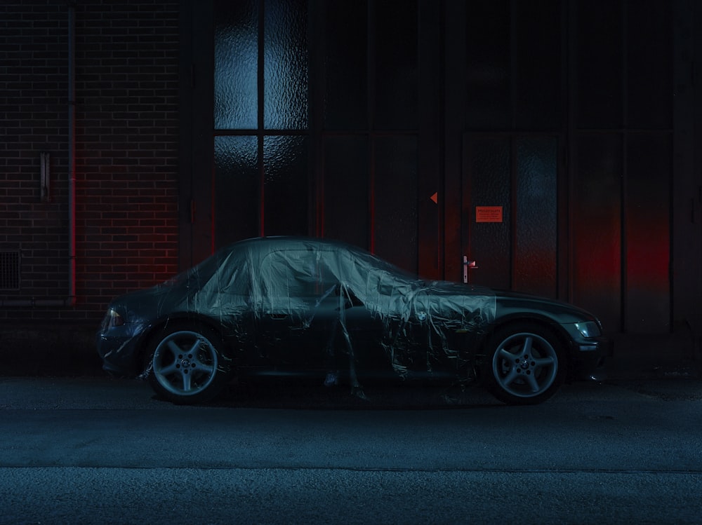 black coupe parked in front of black metal gate