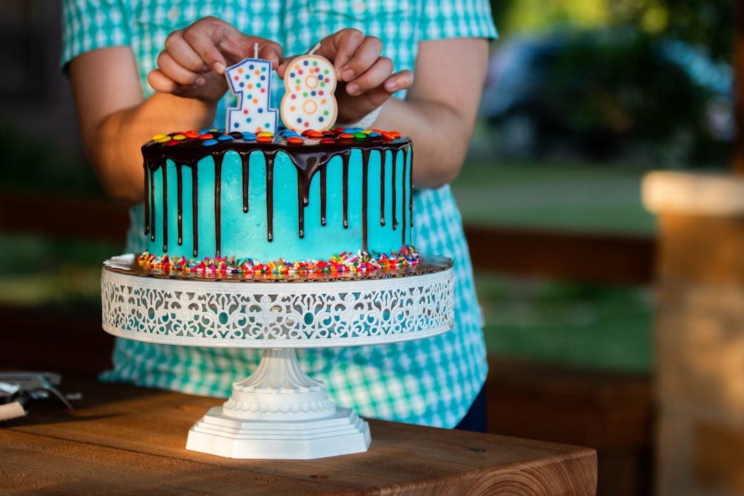 person holding white and blue polka dot cake