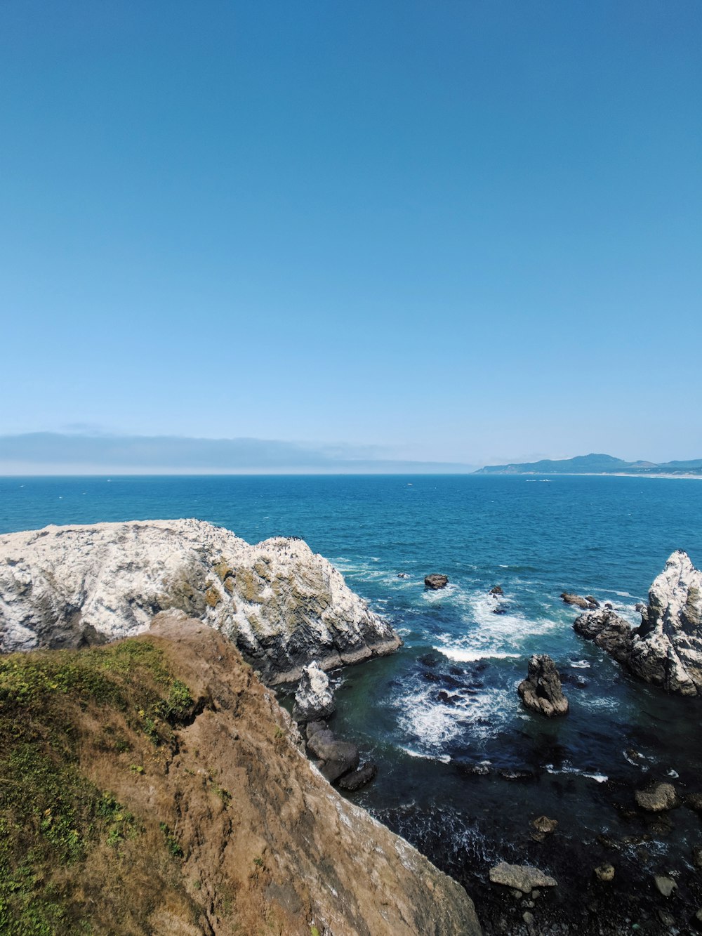 rocky shore under blue sky during daytime