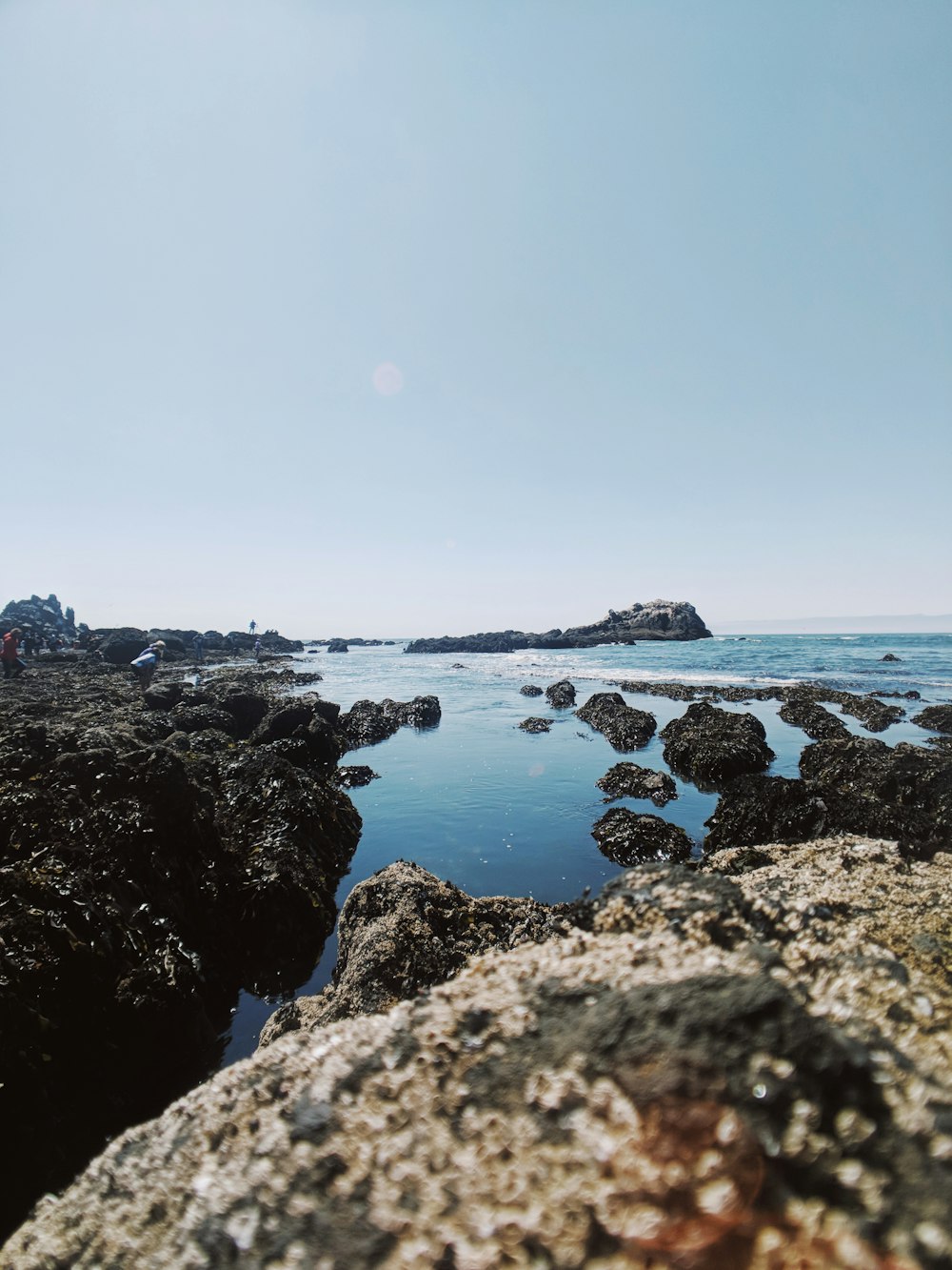 black rock formation on sea during daytime