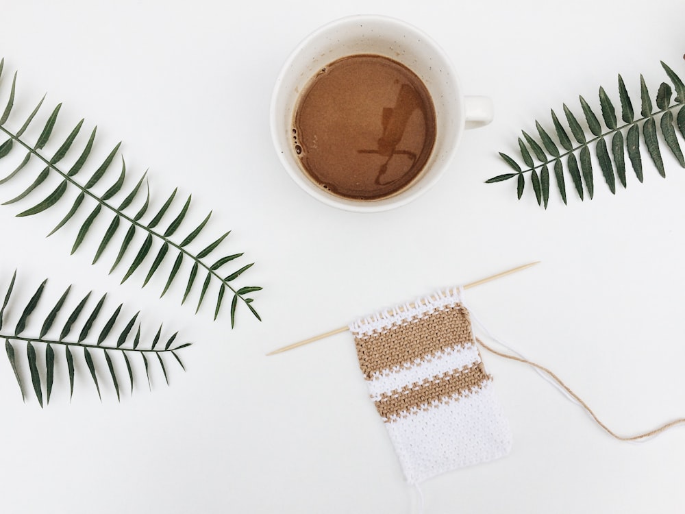 white ceramic mug with brown liquid