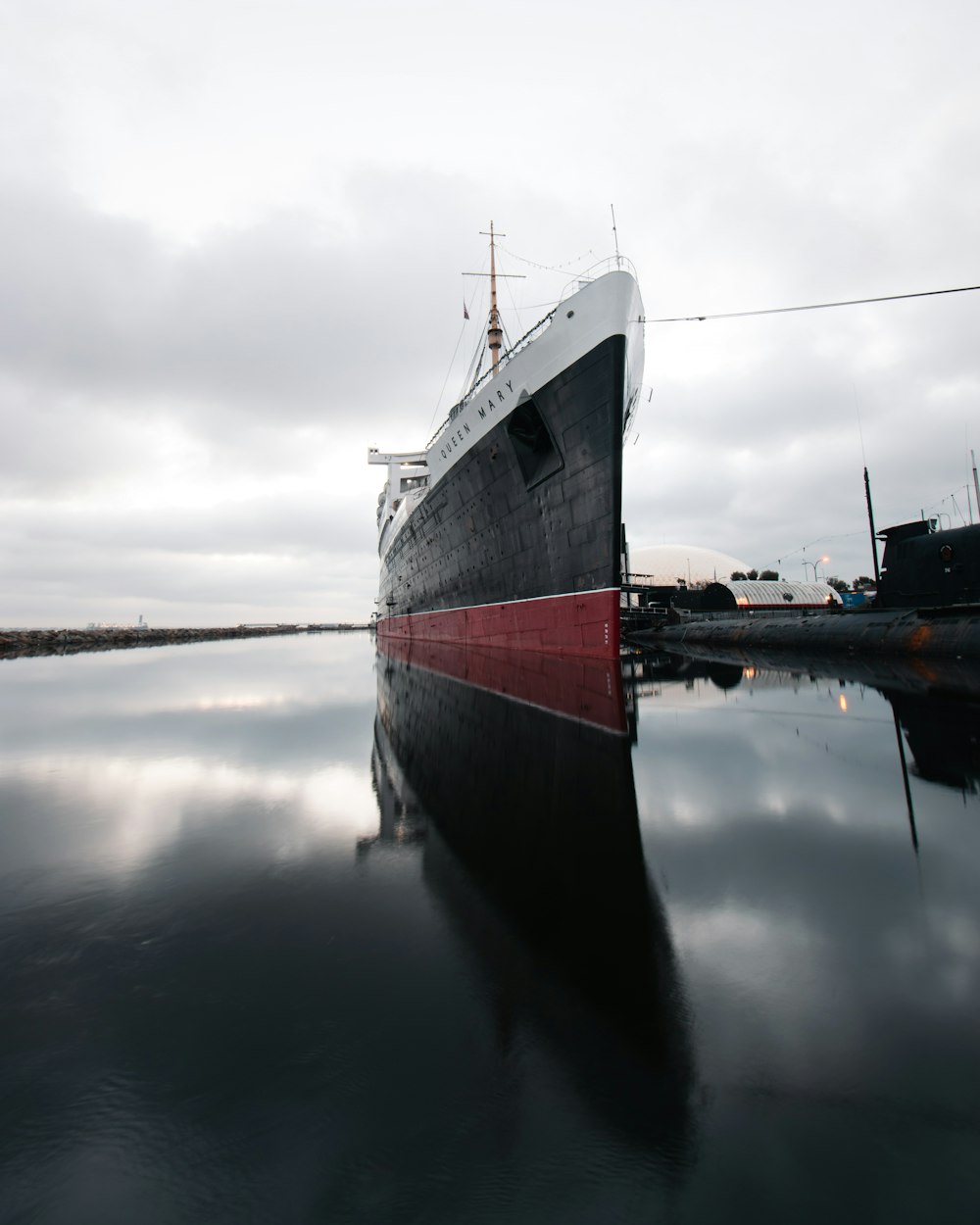 white and red ship on water under gray sky