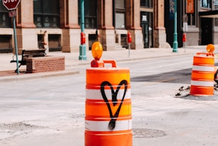 yellow and red traffic cone on gray concrete road