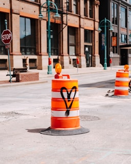 yellow and red traffic cone on gray concrete road