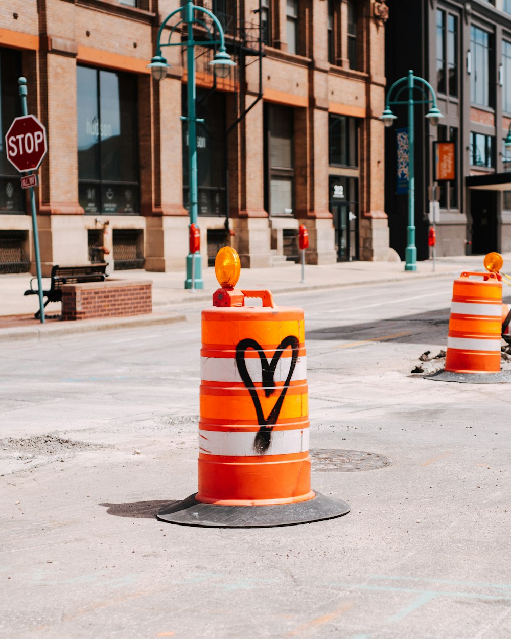 cone de tráfego amarelo e vermelho na estrada de concreto cinza