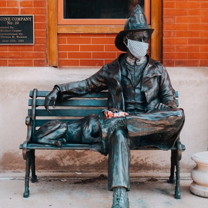 man in black leather jacket sitting on bench