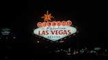 A bright and iconic sign illuminated at night, displaying a warm welcome to Las Vegas, Nevada. The sign is prominently lit with neon lights, featuring the phrase 'Welcome to Fabulous Las Vegas Nevada' with a star at the top.