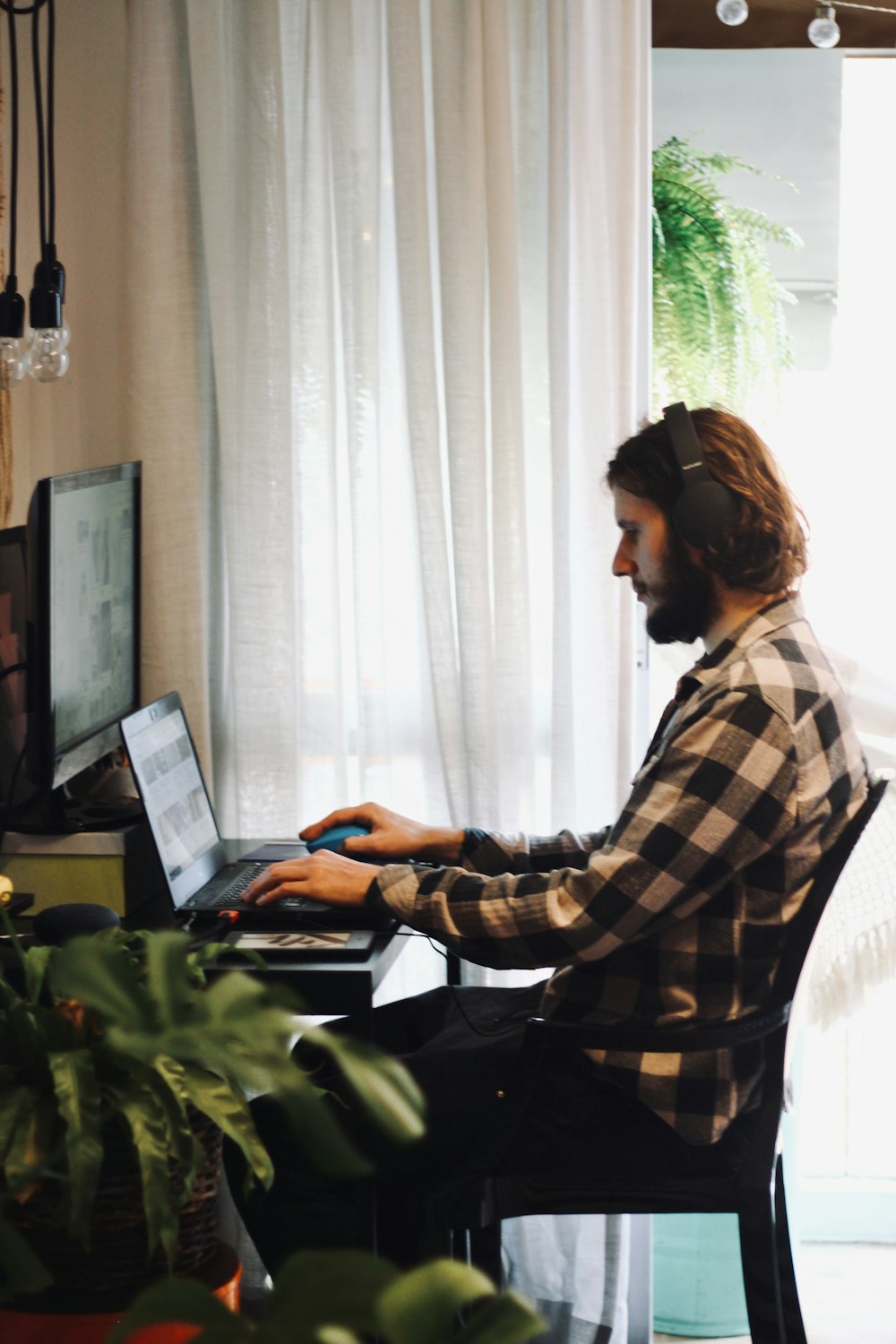 woman in black and white plaid dress shirt using laptop computer