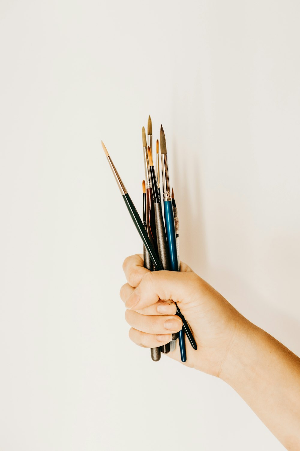 person holding blue pen and white printer paper