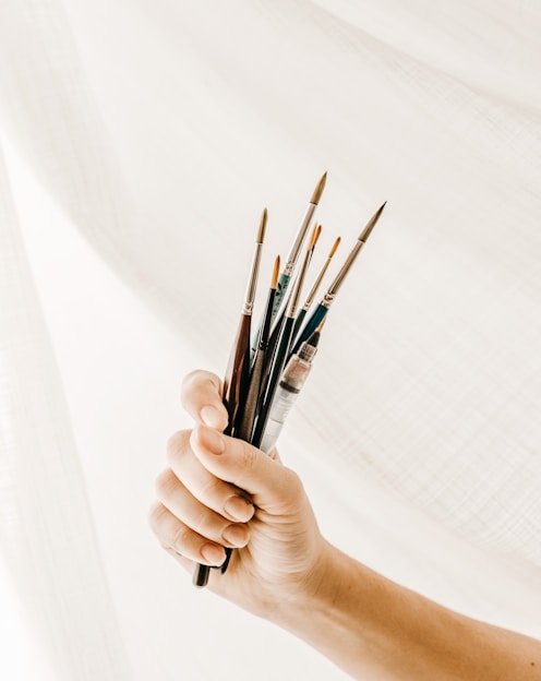 person holding paint brush and brush