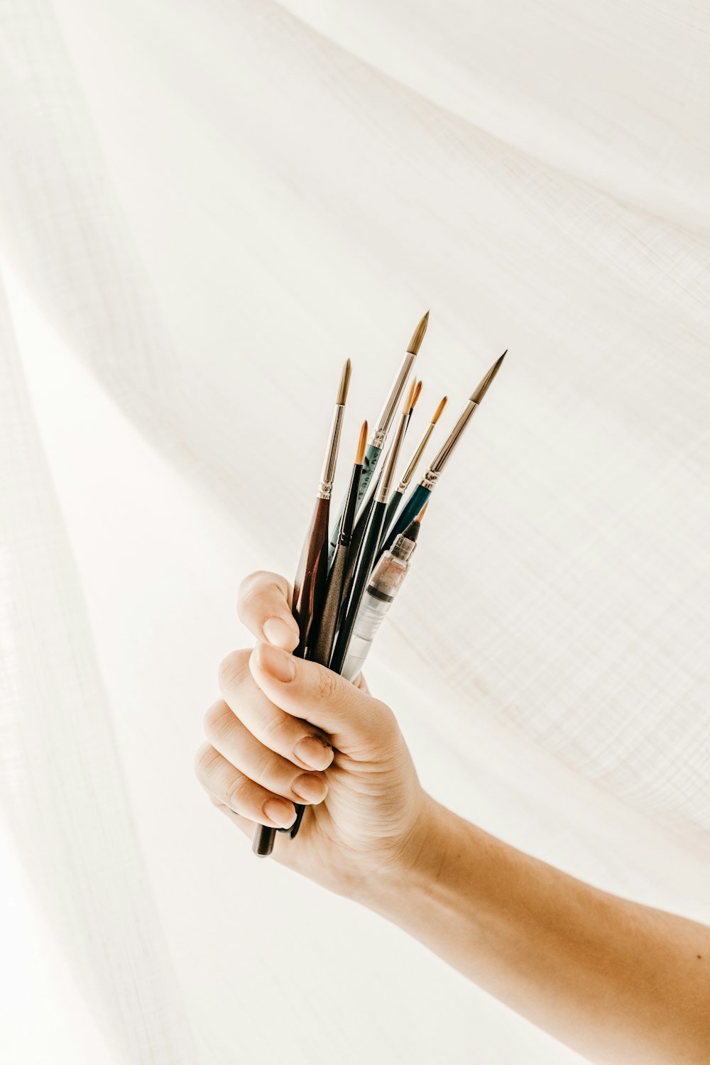 person holding paint brush and brush