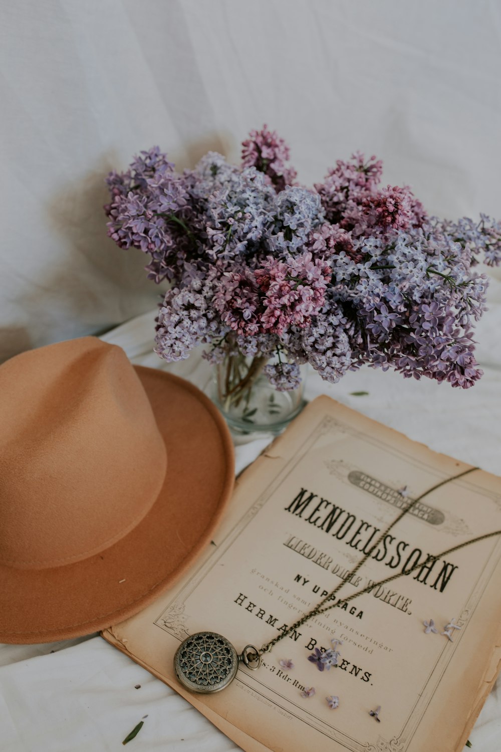 brown cowboy hat beside purple flowers