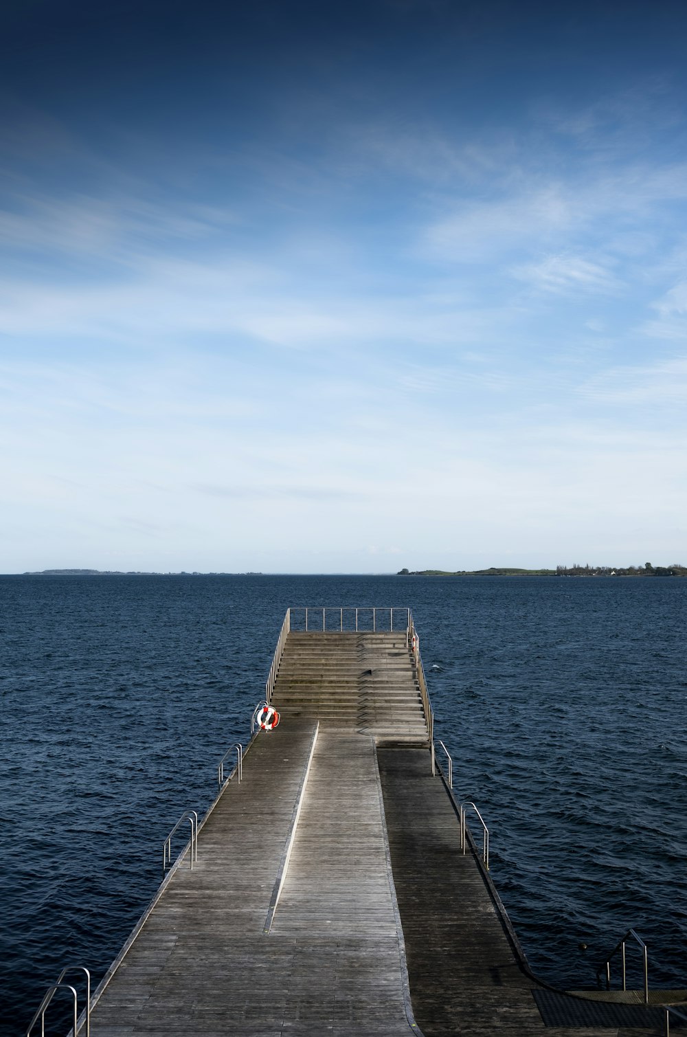 Braunes Holzdock am blauen Meer unter blauem Himmel tagsüber