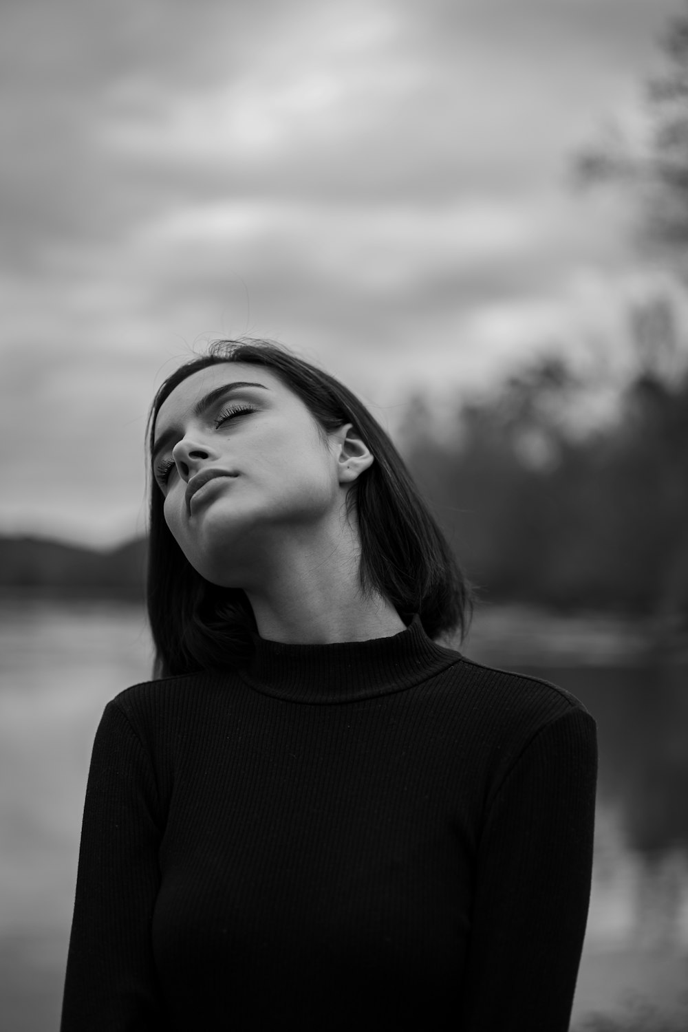 Foto en escala de grises de mujer con suéter de cuello alto