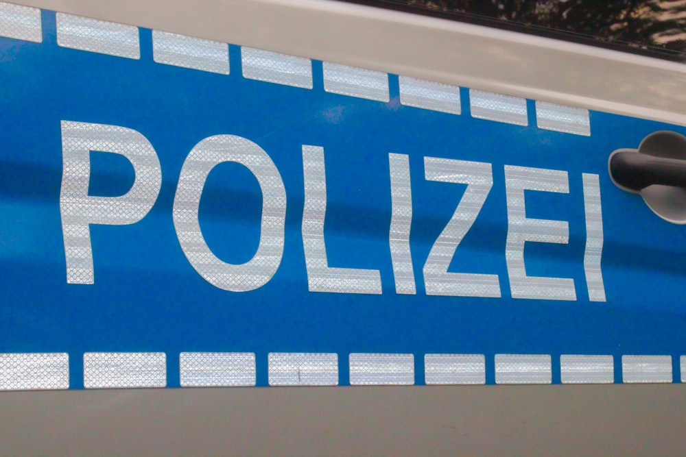 un cartello blu della polizia con lettere bianche su di esso