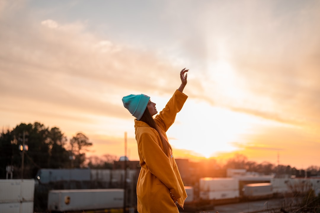 person in yellow jacket raising hand